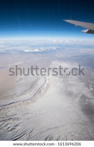 wing of airplane above desert lands