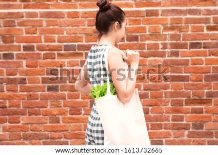 Eco bag in woman hands. Environment concept. Reusable eco bag. White tote bag canvas fabric with fresh food.