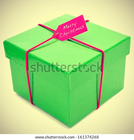 picture of a gift with a pink ribbon and the sentence merry christmas written in a label, with a retro effect
