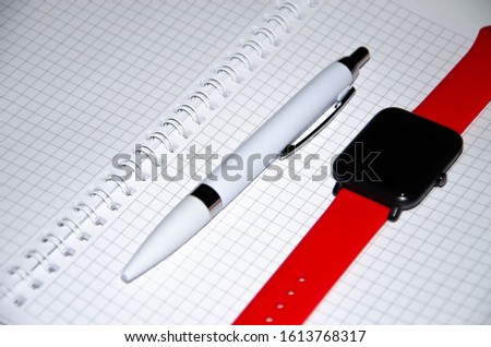 Gray notebook for writing on black background. Ballpoint pen. Smart watch with a red strap. Flat Lai, copies of the paste. View from different sides. Smartphone. Businessmen set kit white background.