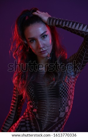 portrait of dancer girl in black clothes in front of purple background in the studio