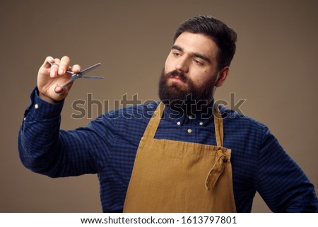 Professional hairdresser in barbershop apron scissors