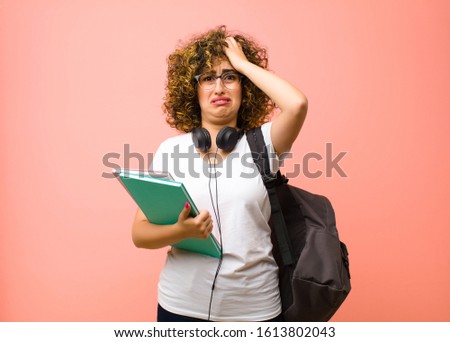 young pretty student woman feeling frustrated and annoyed, sick and tired of failure, fed-up with dull, boring tasks against pink wall