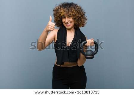 young pretty sports woman wearing fitness clothes lifting a dumbbell
