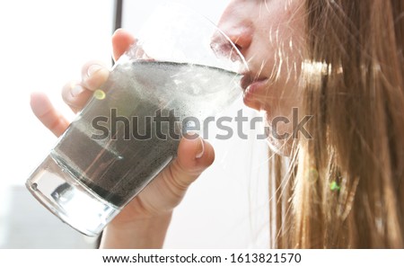 The woman is drinking  dirty water from the glass cup Royalty-Free Stock Photo #1613821570