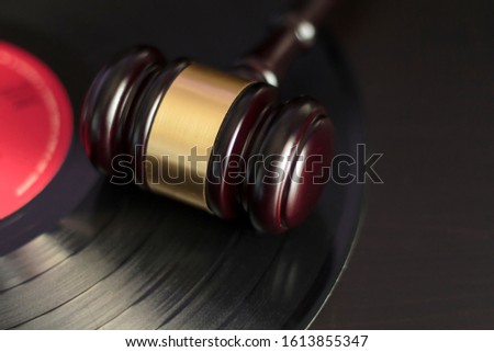 Judge's gavel and vinyl record. Concept of entertainment lawsuit, music piracy and copyright protection Royalty-Free Stock Photo #1613855347