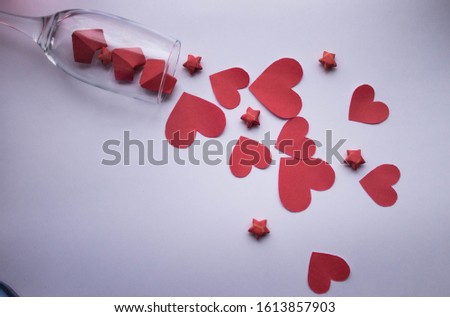 hearts red and red stars fall out of a champagne glass on a white background
