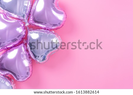 Valentine's Day minimal design concept - Beautiful real heart shape foil balloon isolated on pale pink background, top view, flat lay, overhead above photography.
