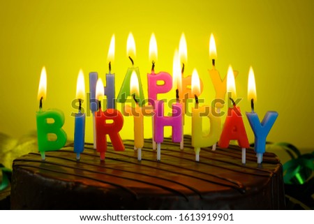 birthday cake with candles on a yellow background