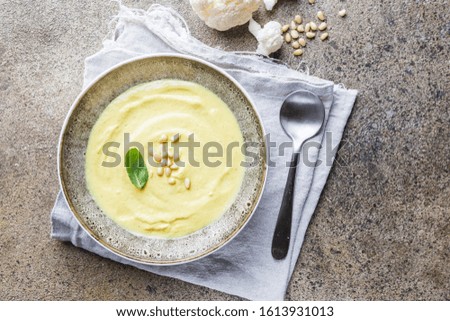 Cauliflower soup puree on a stone background, top view. Vegetarian healthy food concept