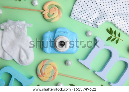 Flat lay composition with toy camera on light green background. Future photographer