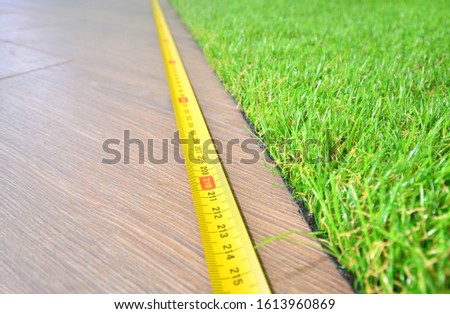 Artificial turf measuring indoors, copy space
