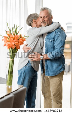 mature woman hugging smiling and handsome man in new house