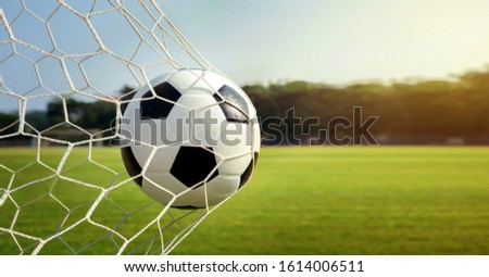 Soccer ball in goal.Football in the sunset.success concept. Royalty-Free Stock Photo #1614006511
