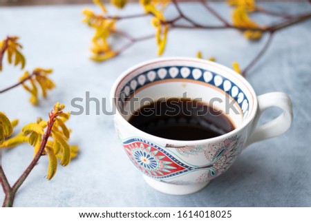 Yellow flowers kangaroo legs on marbled background and white coffee cup