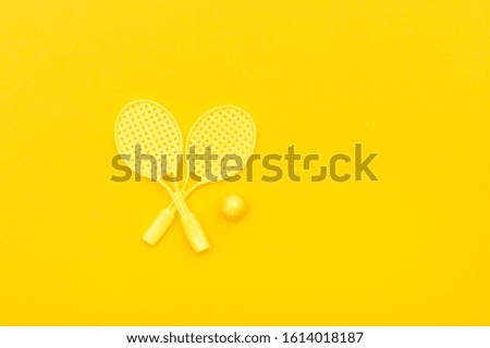 Tennis racket and ball sports on yellow background.