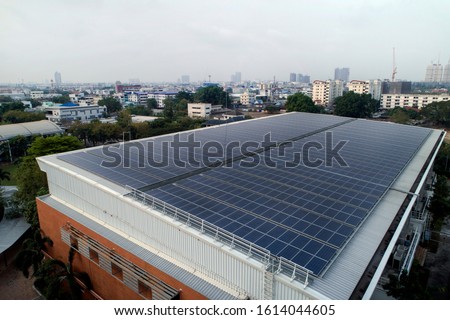 Aerial photo of solar panels on roof of one of the big building in the city, solar panels absorb sunlight as a source of energy to generate electricity creating sustainable energy.