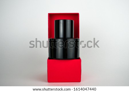 bottle of black perfume in a red box