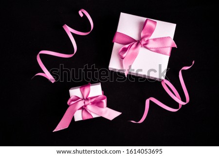 Gift boxes with pink ribbon and decorations on the dark black background, Holiday concept, Presents, Top view