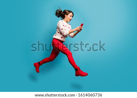 Full length body size view of nice attractive cheerful amazed impressed girl jumping using 5g like follow subscribe running hurry rush isolated on bright vivid shine vibrant blue color background Royalty-Free Stock Photo #1614060736
