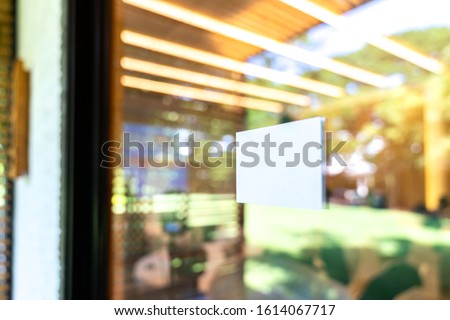 White rectangle are sticked on the glass door in front of seminar hall with blur bokeh background.