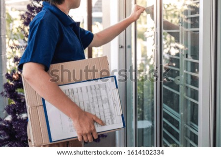 Delivery man deliver box parcel package and clipboard documents sending to customer in front of the house.