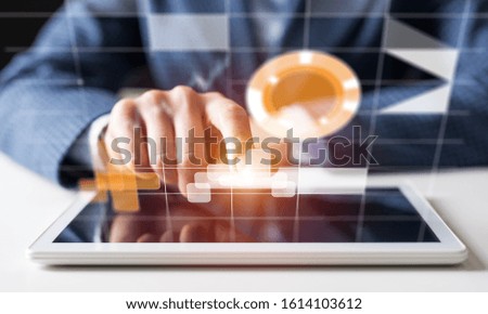 Businessman hand touching virtual screen flying above digital tablet. Online project management and financial diagrams visualization. Modern business innovation and intelligence technology.