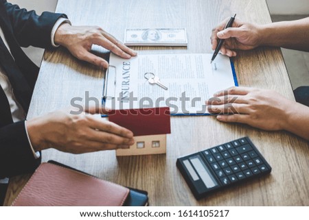 Estate agent giving house and keys to client after signing agreement contract real estate with approved mortgage application form, concerning mortgage loan offer for and house insurance.