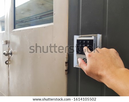 Selective focus of men hand reaching to enter pass code to access the area. In building security or industrial site only for authorized person. Alarm system to secure confidential the area.