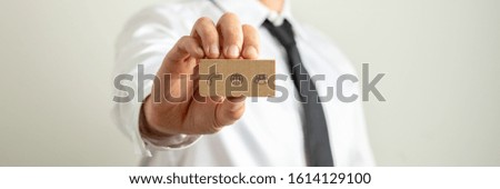 Wide view image of businessman presenting business card with contact and information icons on it.