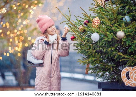 Portrait of adorable little girl going to skate in winter snow day outdoors