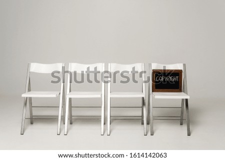 row of chairs and chalkboard with copyright inscription on grey background