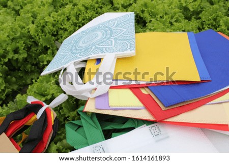 Zero waste concept. Reusable Colorful Fabric Shoping bags isolated on green. Copy space for text. Reduce, Reuse, Recycle, save earth. World Environment Day. Polypropylene Grocery Bags