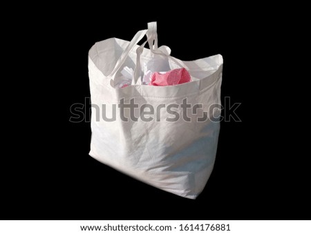 Close-up of trendy eco-friendly canvas white bag on black background. Box Type shopping bag. Promotion and Presentation Bag. Non Woven Polypropylene Bag isolate on black background