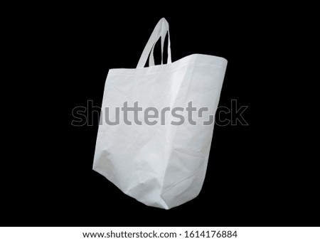 Close-up of trendy eco-friendly canvas white bag on black background. Box Type shopping bag. Promotion and Presentation Bag. Non Woven Polypropylene Bag isolate on black background