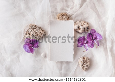 Feminine wedding, birthday mockup scene. Watercolor textured paper greeting cards, stones, orchidea flowers. White textile on a table background. Flat lay, top view