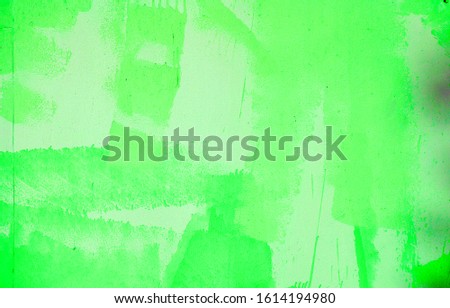 Wall with peeling plaster, tinted in green. Modern urban building concept. Bright neon backdrop. Selective focus