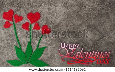 Holiday background for Valentine's Day on a gray cement background with red hearts laid out in the form of a flower