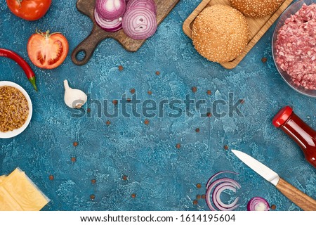 top view of fresh burger ingredients on blue textured surface