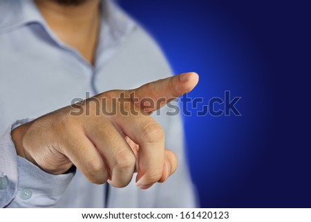 young men pointing his finger to click virtual display against blue background