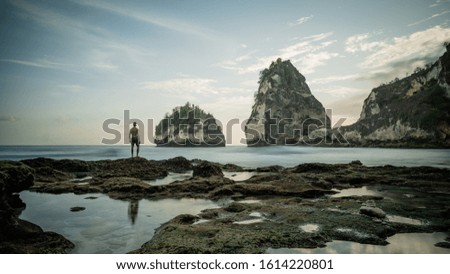 
Nature photographer in the action. Man silhouette rock in the ocean at Atuh beach on Nusa Penida island, Indonesia, Bali