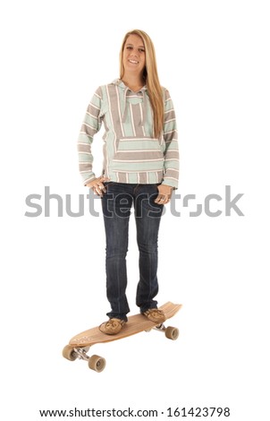 blonde woman standing on skate  board smiling 