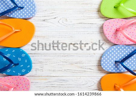 a lot of flip flop colored sandals, summer vacation on wooden background, copy space top view.