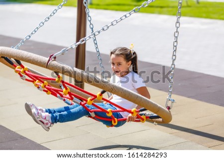 attractive little girl on outdoor playground equipment