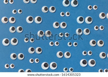 Googly plastic eyes used to imitate eyeballs for craft toys and dolls and others creativity on a blue backgroud. Top view.
