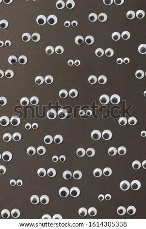 Googly plastic eyes pattern used to imitate eyeballs for toys and dolls and others creativity on a black backgroud. Top view.