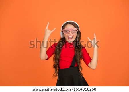 Cool track. Event and entertainment. Party girl. Party accessory. Having fun. Play list for party. Music concept. Kid wear eyeglasses. Eyewear fashion store. Girl with eyeglasses orange background.