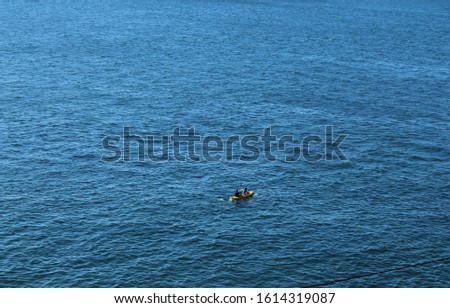 blue ocean with small boat sailing