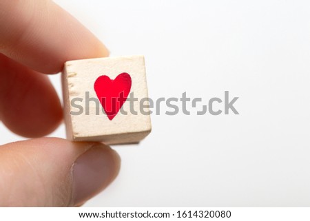 Hand hold wooden cubes with red heart symbol isolated on white background. Emotion concept. space for text
