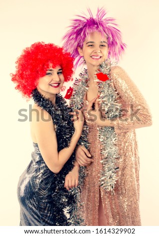 Attractive playful young women ready for carnival parties. Lifestyle and the concept of friendship: a group of two girl friends.